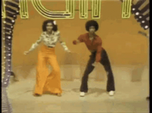 A Man And A Woman Are Dancing On A Stage In Front Of A Sign That Says ' I Love You ' . GIF