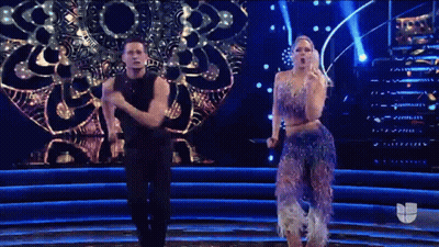 A Man And A Woman Are Dancing On A Stage GIF