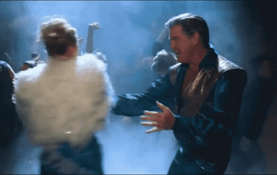 A Man And A Woman Are Dancing Together In A Dark Room GIF