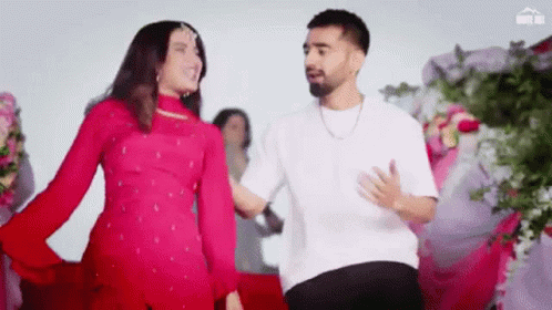 A Man And A Woman Are Dancing Together In A Room . GIF