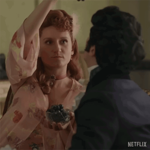 A Man And A Woman Are Dancing Together In A Room . The Woman Is Wearing A Pink Dress And A Choker . GIF