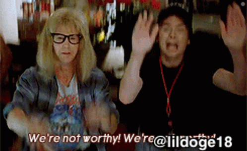 A Man And A Woman Are Dancing With The Words We 'Re Not Worthy Written Above Them GIF