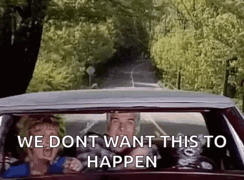 A Man And A Woman Are Driving A Car Down A Country Road . GIF
