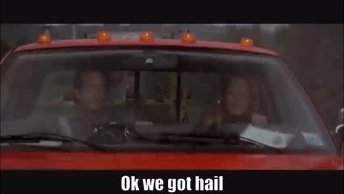 A Man And A Woman Are Driving A Red Truck With The Words `` Ok We Got Hail '' Written On The Bottom . GIF