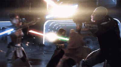 A Man And A Woman Are Fighting With Lightsabers In A Dark Room GIF