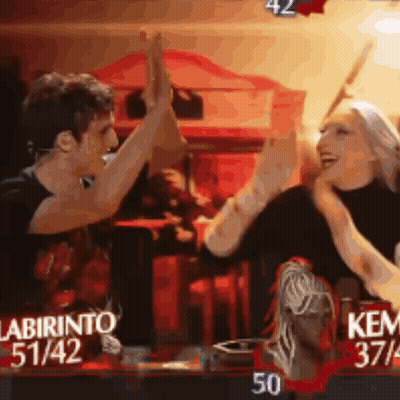 A Man And A Woman Are Giving Each Other A High Five In Front Of A Sign That Says Labirinto 51/42 GIF