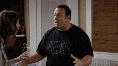 A Man And A Woman Are Having A Conversation In A Living Room . GIF