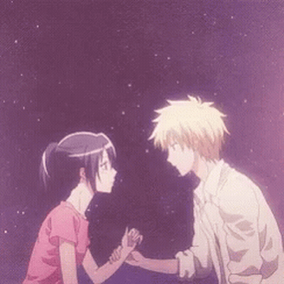 A Man And A Woman Are Holding Hands And Looking At Each Other GIF