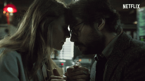 A Man And A Woman Are Holding Hands With A Netflix Logo In The Background GIF