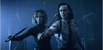 A Man And A Woman Are Holding Knives In A Dark Room . GIF