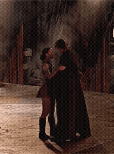 A Man And A Woman Are Hugging And Kissing On The Floor GIF