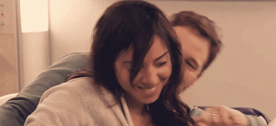 A Man And A Woman Are Hugging And Smiling GIF