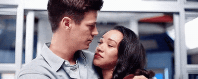 A Man And A Woman Are Hugging Each Other And Looking At Each Other In A Room . GIF