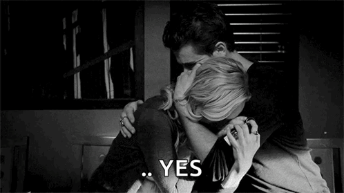 A Man And A Woman Are Hugging Each Other In A Black And White Photo And The Woman Is Saying Yes . GIF