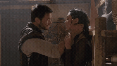 A Man And A Woman Are Hugging Each Other In A Dark Room GIF