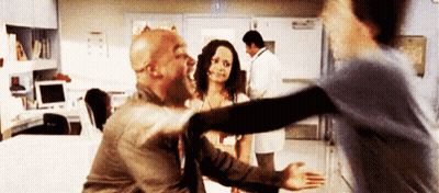 A Man And A Woman Are Hugging Each Other In A Hospital . GIF