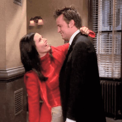 A Man And A Woman Are Hugging Each Other In A Room GIF
