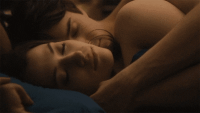 A Man And A Woman Are Hugging Each Other In Bed GIF