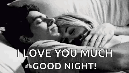A Man And A Woman Are Hugging Each Other In Bed . GIF