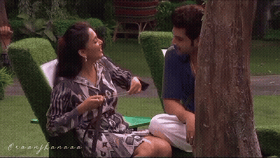 A Man And A Woman Are Hugging Each Other In Front Of A Sign That Says ' Hotel ' On It GIF