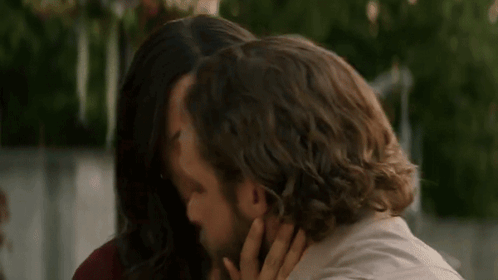 A Man And A Woman Are Hugging Each Other . The Woman Is Touching The Man 'S Face . GIF