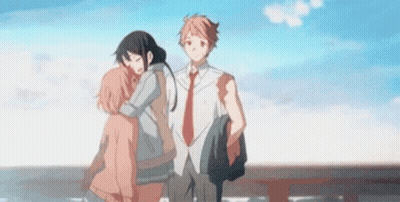 A Man And A Woman Are Hugging Each Other While Standing Next To Each Other On A Bridge . GIF