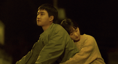 A Man And A Woman Are Hugging Each Other With The Woman 'S Head On The Man 'S Shoulder GIF