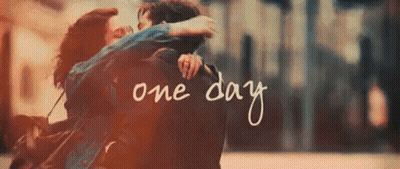 A Man And A Woman Are Hugging Each Other With The Words One Day Written In The Background . GIF
