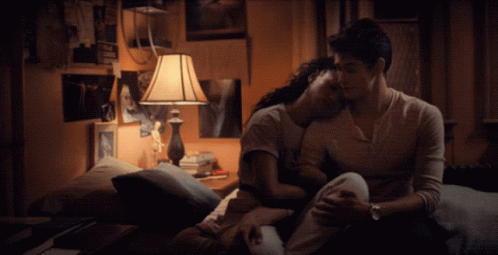 A Man And A Woman Are Hugging On A Bed GIF