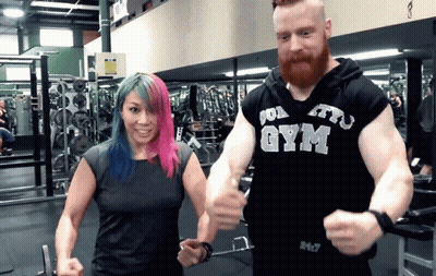 A Man And A Woman Are In A Gym And The Man Is Wearing A Gym Hoodie GIF