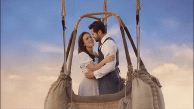 A Man And A Woman Are In A Hot Air Balloon . GIF