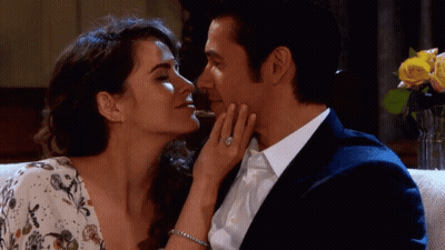 A Man And A Woman Are Kissing And The Woman Has A Diamond Ring On Her Finger GIF