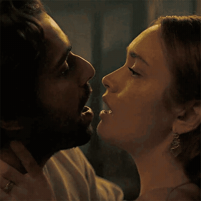 A Man And A Woman Are Kissing And The Woman Is Biting The Man 'S Nose . GIF