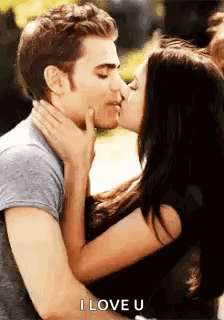 A Man And A Woman Are Kissing And The Woman Is Holding The Man 'S Face . GIF