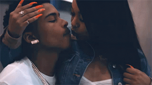 A Man And A Woman Are Kissing And The Woman Is Wearing A Ring On Her Finger GIF