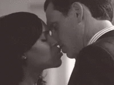 A Man And A Woman Are Kissing Each Other In A Black And White Photo . GIF