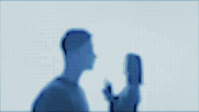 A Man And A Woman Are Kissing Each Other In A Dark Room . GIF