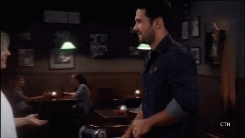 A Man And A Woman Are Kissing Each Other On A Television Screen . GIF