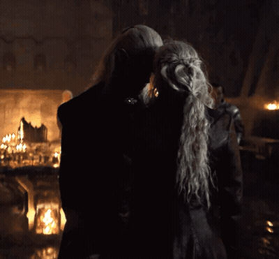 A Man And A Woman Are Kissing In A Dark Room . GIF