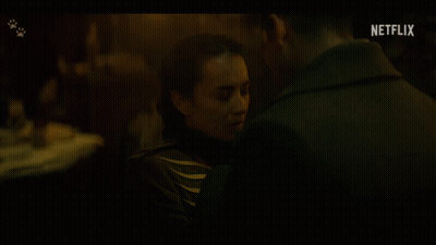 A Man And A Woman Are Kissing In A Dark Room With A Netflix Logo In The Background GIF
