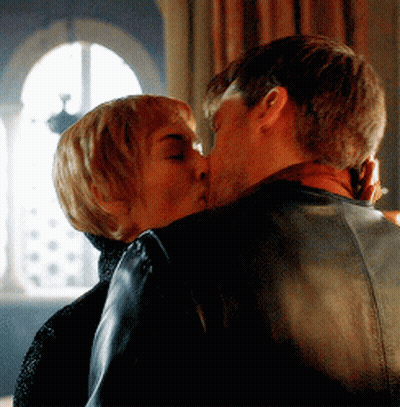 A Man And A Woman Are Kissing In A Room GIF
