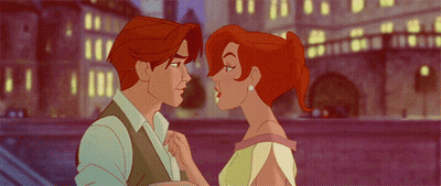 A Man And A Woman Are Kissing In Front Of A Bridge GIF