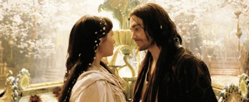 A Man And A Woman Are Kissing In Front Of A Fountain GIF