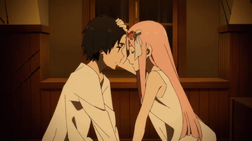 A Man And A Woman Are Kissing In Front Of A Wooden Wall GIF