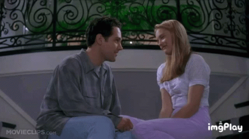 A Man And A Woman Are Kissing In Front Of A Wrought Iron Railing With A Movieclips.com Watermark GIF