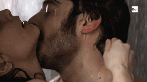 A Man And A Woman Are Kissing In The Rain With Rai Written On The Bottom GIF