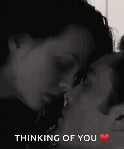 A Man And A Woman Are Kissing With The Words `` Thinking Of You '' Written Below Them . GIF