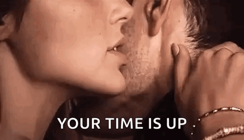 A Man And A Woman Are Kissing With The Words `` Your Time Is Up '' Behind Them . GIF