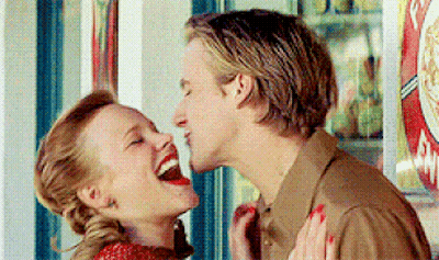 A Man And A Woman Are Laughing And Kissing In Front Of A Vending Machine GIF