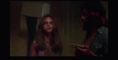 A Man And A Woman Are Laughing In A Dark Room . GIF